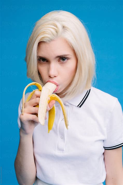 Attractive blonde girl eating banana seductively by Javier Díez - Stocksy United