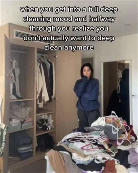 a person standing in front of a closet with clothes on the floor and an ...