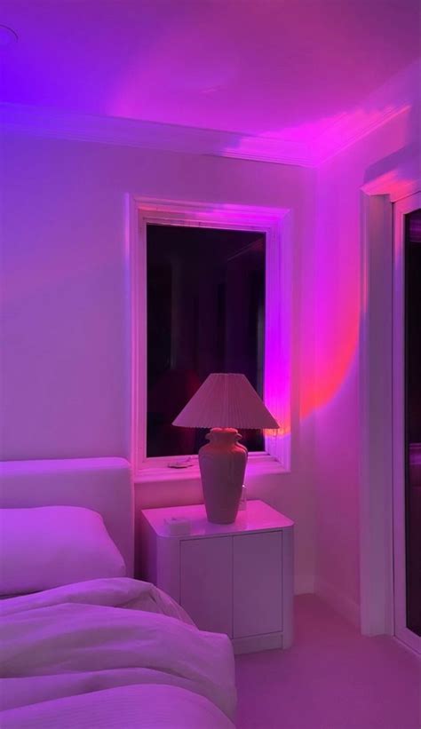 a bedroom with a purple light in the corner and a lamp on the end table