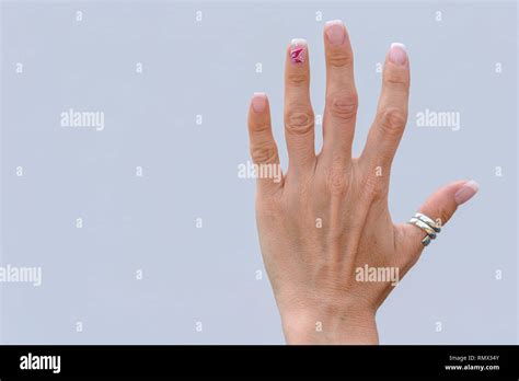 Hand of an older woman with manicured nails wearing a silver thumb ring ...