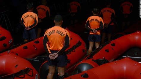 men in orange vests standing next to rafts with life jackets over their ...