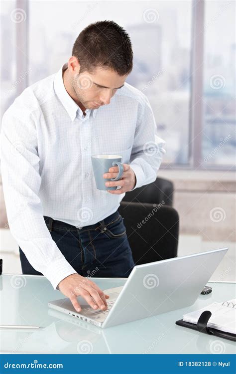 Young Man Working On Laptop In Bright Office Royalty Free Stock Photos - Image: 18382128