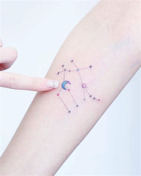 Gemini constellation tattoo on the right inner forearm.