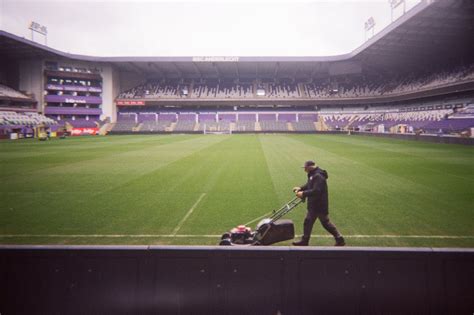 Man Mowing Grass in an Empty Soccer Stadium · Free Stock Photo