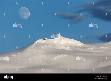 Snow-covered Snæfell volcano with Snæfellsjökul glacier and full moon, near Hellissandur ...