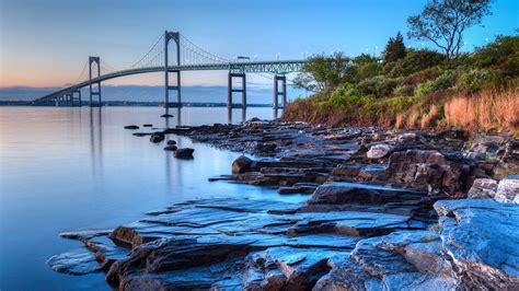 Claiborne Pell Newport Bridge with rocky seascape at sunrise, Jamestown, Rhode Island, USA ...