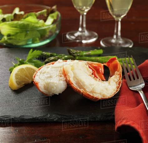 Lobster tails with lemon, asparagus and salad - Stock Photo - Dissolve