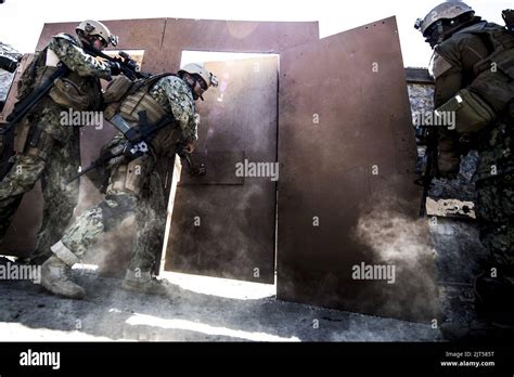 U.S. Navy Mass Communication Specialist 1st Class busts open a door ...