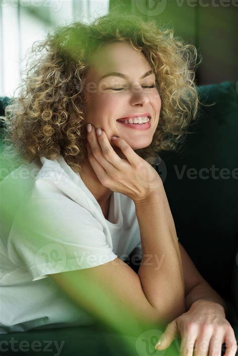 Beautiful woman with curly hair lying on green sofa 16237795 Stock ...