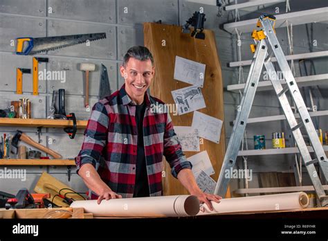 A carpenter works. Carpenter studying drawing project. Against the background of the workshop ...