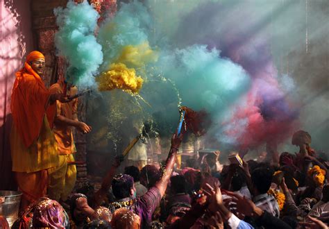 Hindu priests throws coloured powder at the devotees during Holi celebrations at Bankey Bihari ...