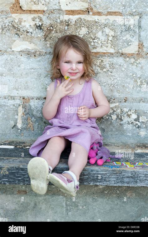 Little girl sitting on curb, portrait Stock Photo - Alamy