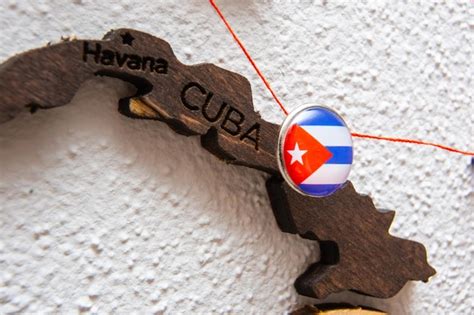 Premium Photo | Cuba flag on the pin with red thread showed the paths on the wooden map