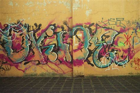 Colorful graffiti on old cement wall above street pavement · Free Stock ...