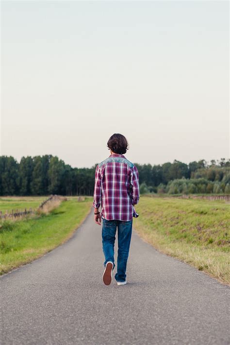 «Teenage Boy Walking Away On A Long Road In The Fields» del colaborador ...