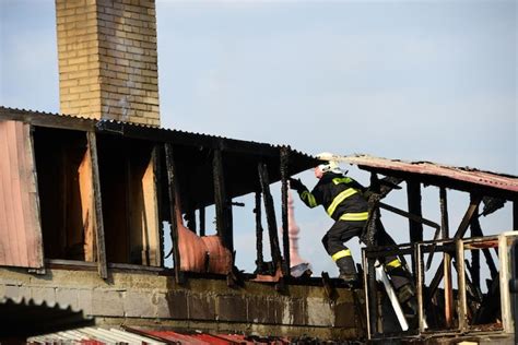 Premium Photo | Strong and brave firefighters on burning house are trying to extinguish open ...