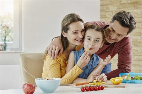 Happy family at home preparing healthy food stock photo