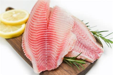 Premium Photo | Fresh fish fillet sliced for steak or salad with herbs spices rosemary and lemon ...
