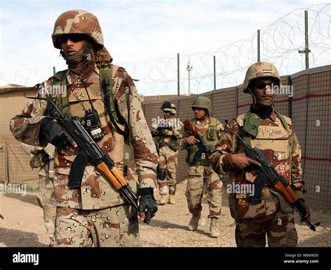 Iraqi Army soldiers load their weapons and conduct a final gear inspection prior to embarking on ...