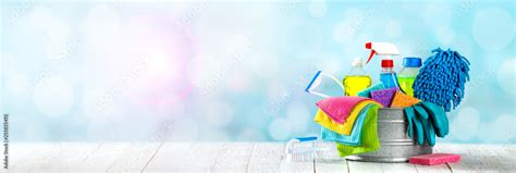 Bucket Of Cleaning Supplies On Wooden Table With Clean Blue Bubbly Background - Cleaning ...