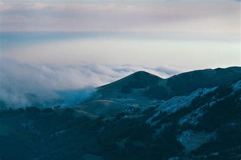 Green hills covered with forest and thick clouds · Free Stock Photo