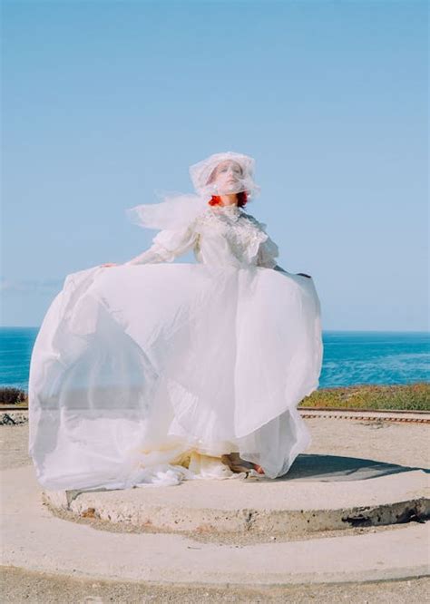 Woman in White Strapless Sweetheart Wedding Dress With Rose Bouquet ...