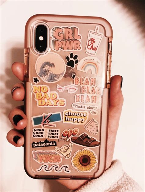 a person holding a phone case with stickers on it