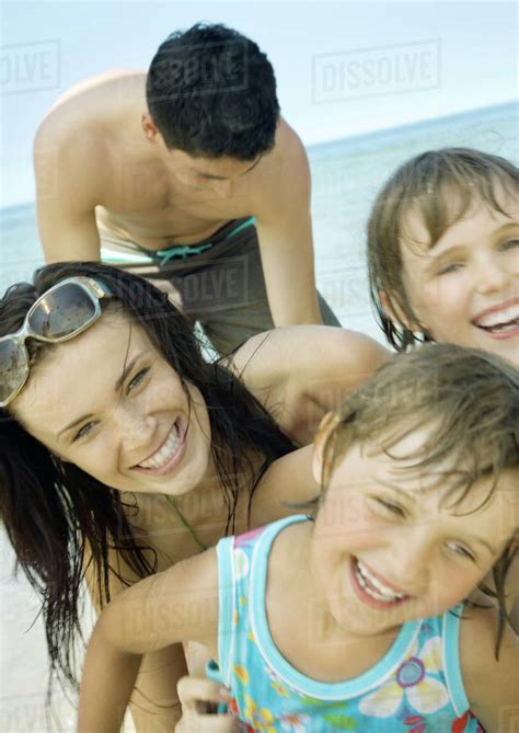 Family laughing on beach, close-up - Stock Photo - Dissolve