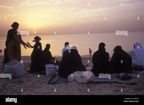 Kuwaitis enjoy an evening sunset on the beach around the capital Stock ...