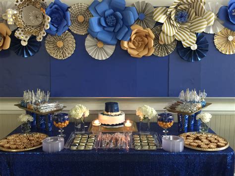 Royal blue and gold dessert table with paper flowers and fan as backdrop | Gold dessert table ...