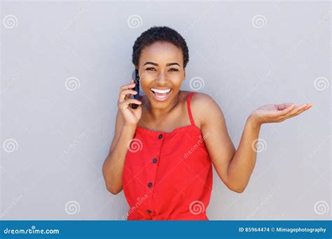 Smiling African Woman Talking on Cell Phone with Hand Raised Stock Photo - Image of cell, gray ...