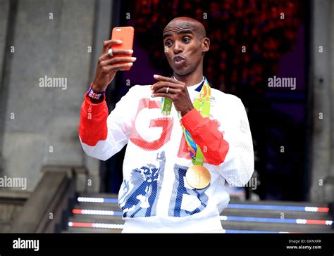 Great Britain's Mo Farah with his gold medals for victory in the Men's 5000m and 10000m during a ...