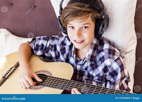 Teenage Boy Playing Acoustic Guitar in Bed Stock Photo - Image of ...