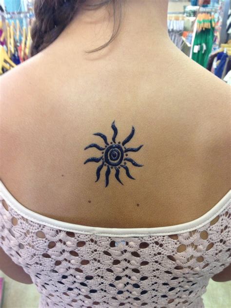 a woman with a sun tattoo on her upper back shoulder and arm, in a store