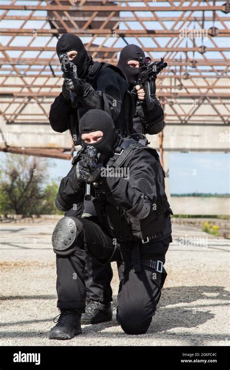 Special forces operators in black uniform in action Stock Photo - Alamy