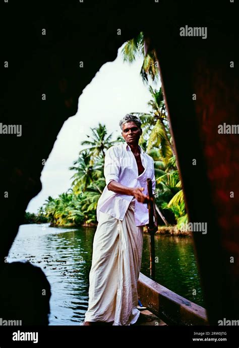 A boatman poles his kettuvallam through Vembanad Lake in the backwaters ...