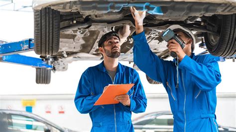 Download Proficient Mechanical Engineer Technician Inspecting a Car Wallpaper | Wallpapers.com