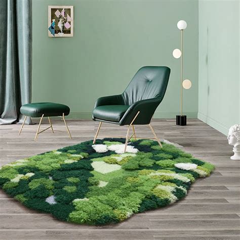 a living room with green walls and rugs on the floor, chair and ottoman