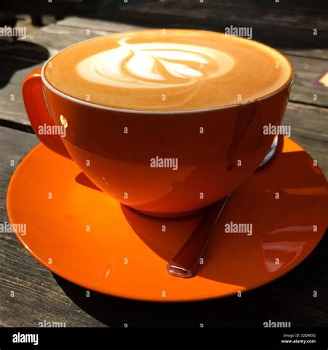 Flat white coffee in orange cup Stock Photo - Alamy