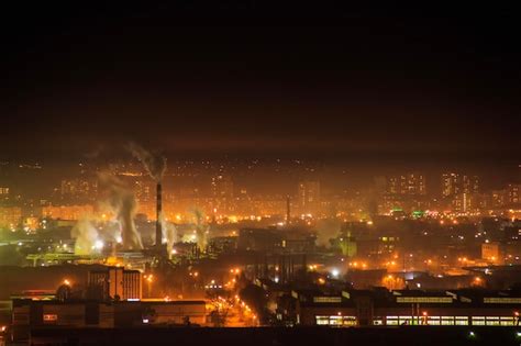 Premium Photo | Night city industrial zone smoke from the pipes of manufacturing