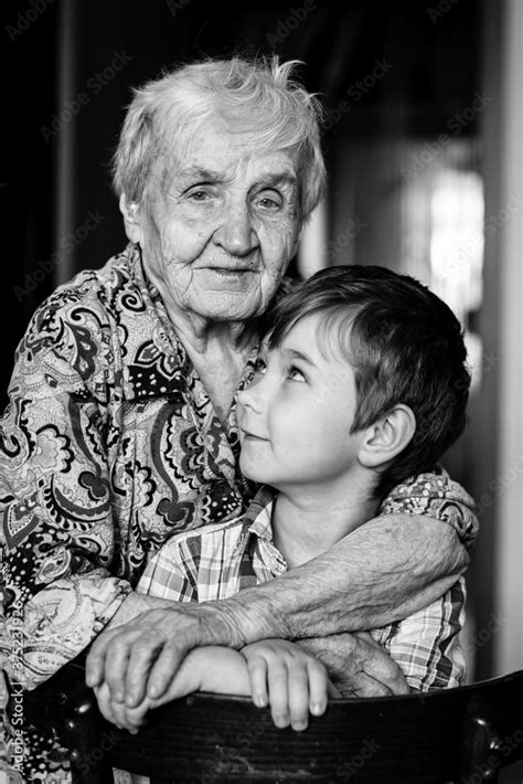 An old woman and grandson posing for the camera. Black and white ...