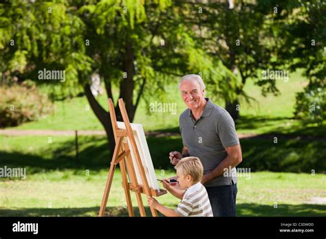 Grandfather and his grandson painting in the garden Stock Photo - Alamy