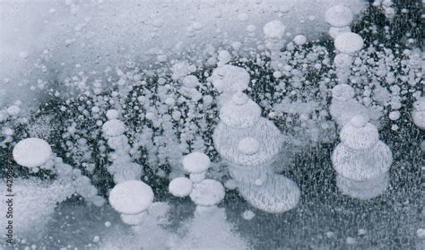 Frozen Baikal lake with cracks and methane bubbles on the transparent ...