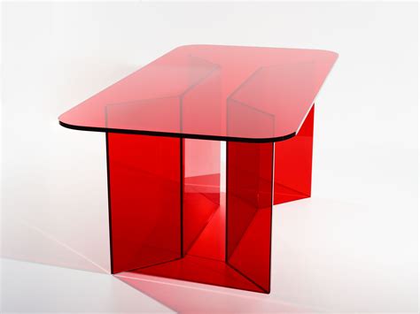 a red glass table sitting on top of a white floor