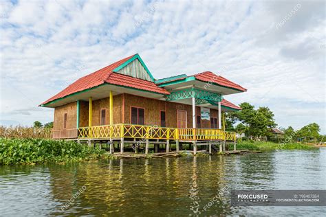 Indonesia, Sulawesi Selatan, Kabupaten Wajo, Colorful house on stilts in water in lake Danau ...