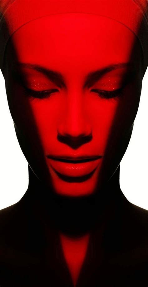 a woman's face is shown with red light coming from her eyes and head
