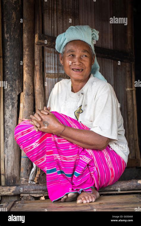 Hill tribe woman from the white Karen (Kayin) people siting in traditional dress, in the door of ...