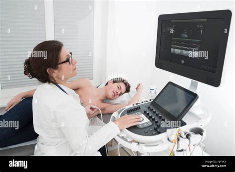 Female cardiologist performs echocardiogram of the heart on teenage ...