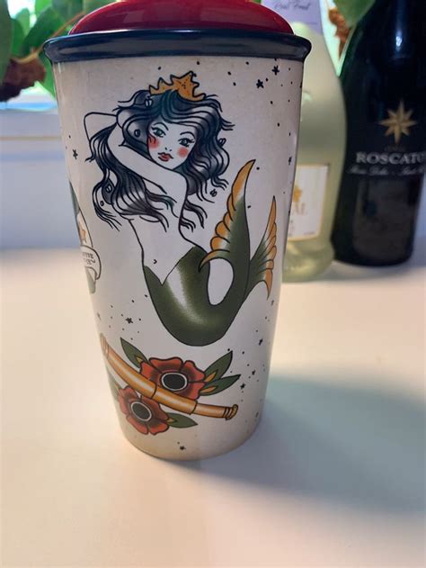 there is a cup with a mermaid on it