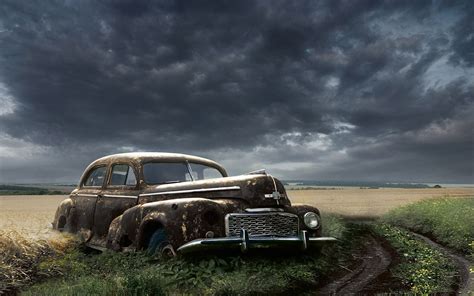 Rusty car in the middle of the nature near the country road